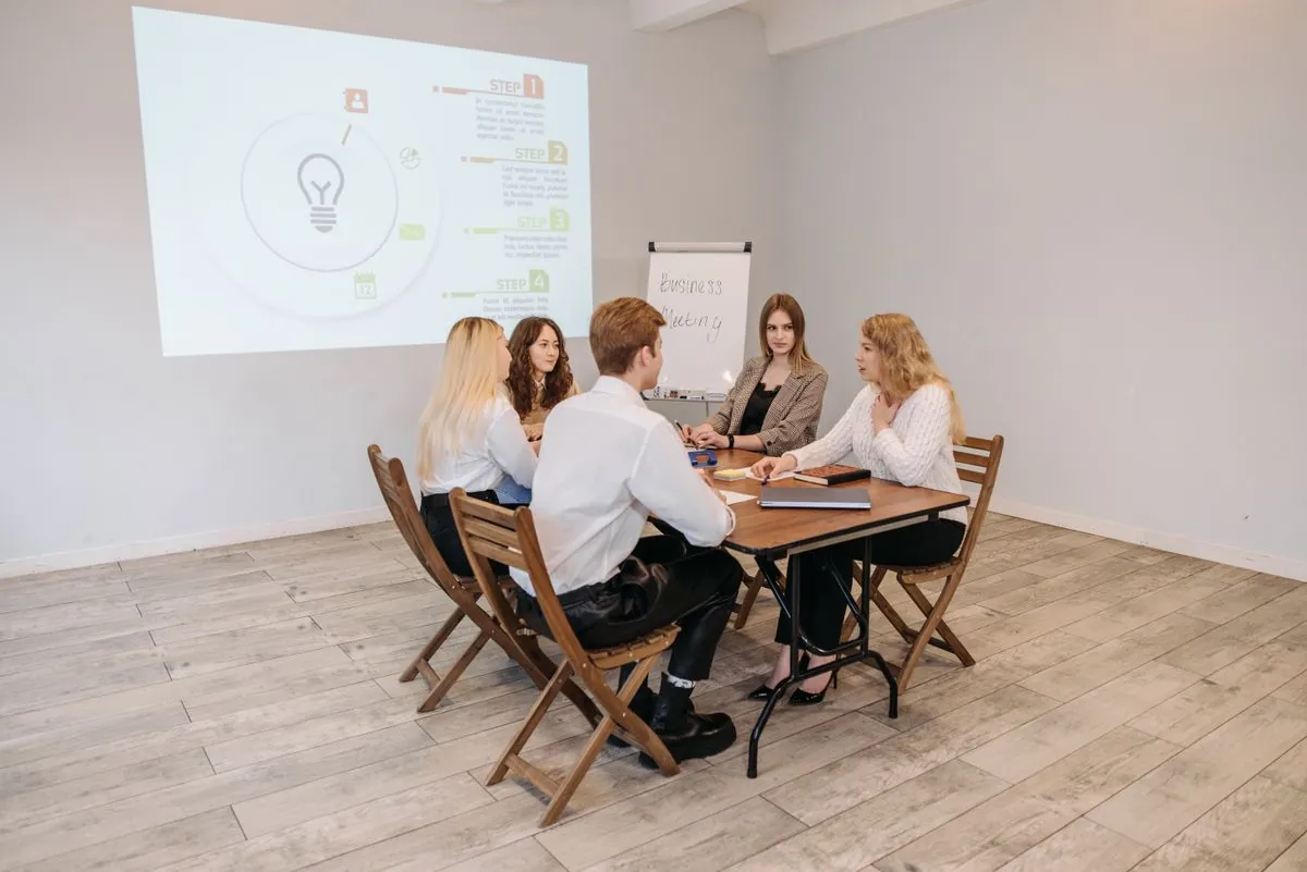 Réunion professionnelle autour d'une table dans une salle de réunion équipée